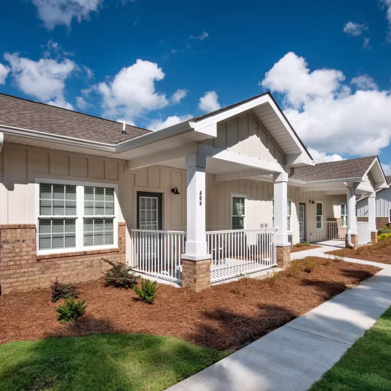 Single-story board-and-batten homes with covered porches and landscaped walkways